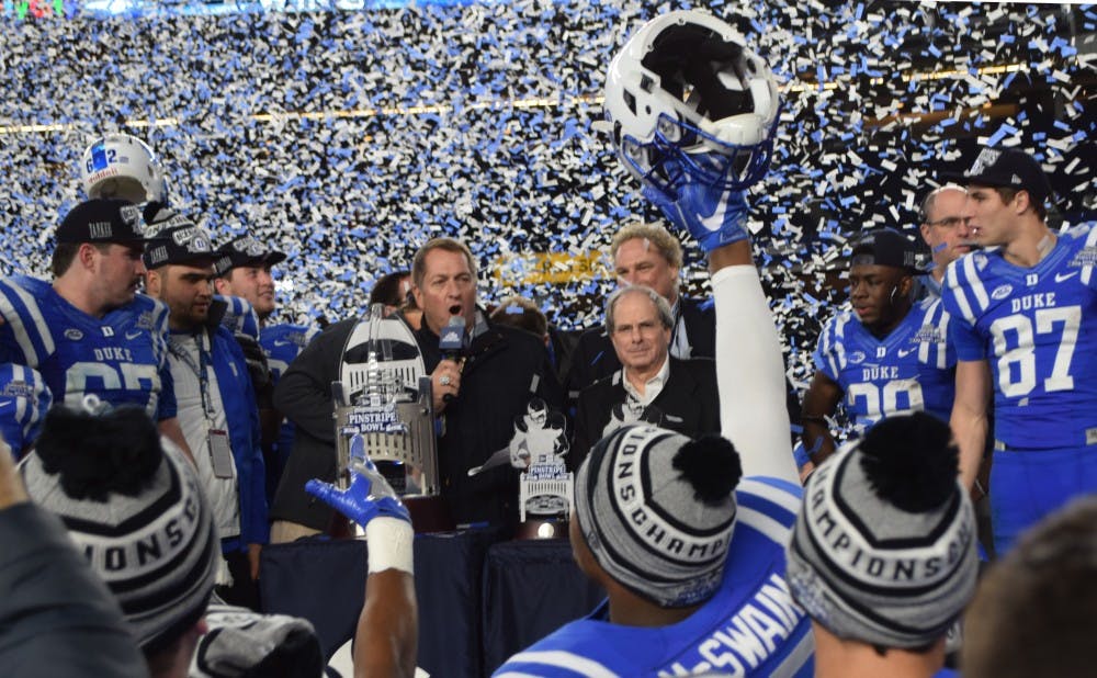 The Blue Devils receive the Pinstripe Bowl trophy after Saturday's win.