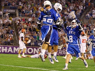 Senior Max Quinzani, who scored the game-winning goal in Duke's 14-13 win, rushes to join the celebration at midfield.