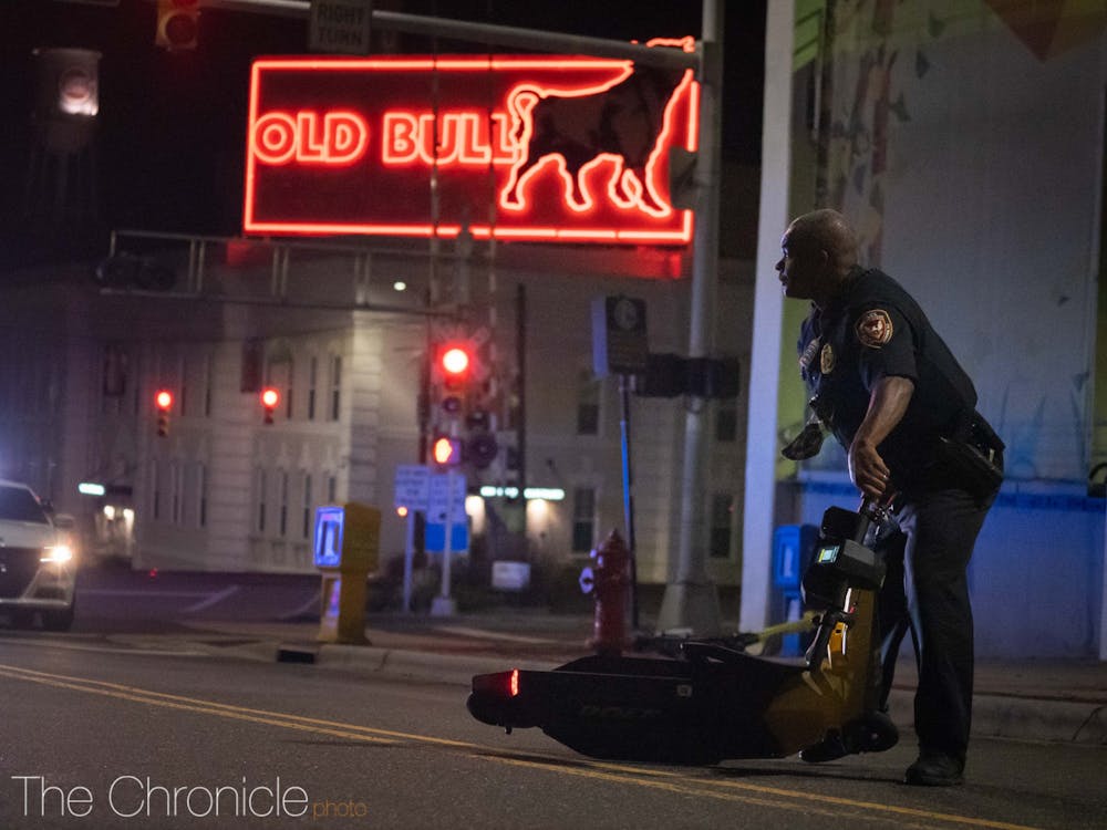 A police officer clears an electric scooter blocking the roadway left behind by protesters.