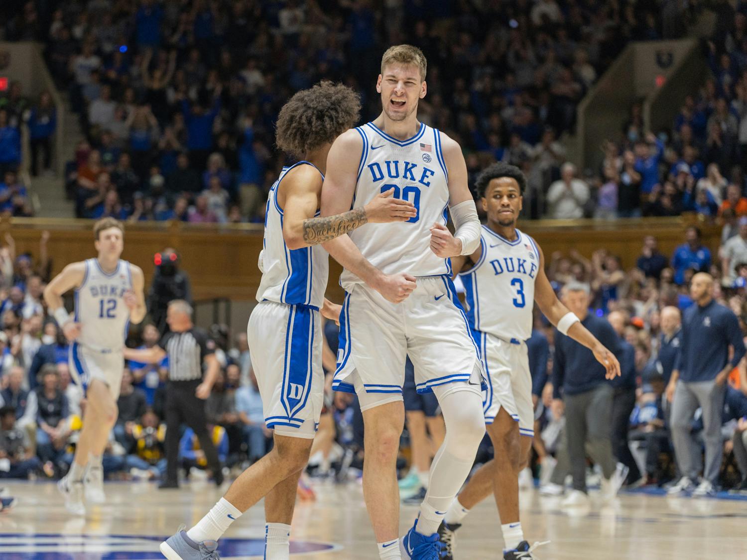 Kyle Filipowski celebrates with Tyrese Proctor during the first half of Duke's matchup with Virginia.