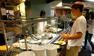 A student is served food at the Marketplace.  Administrators and students recently rejected a proposed first-year dining plan that would have increased the number of Marketplace meals included per week.