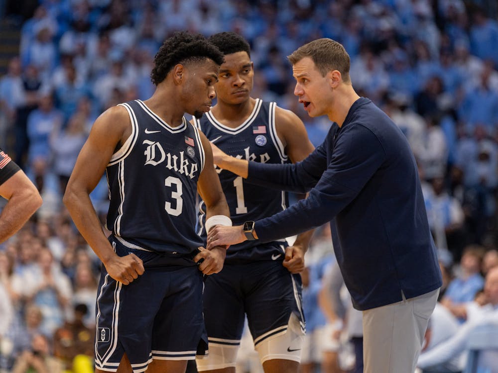 Head coach Jon Scheyer instructs guards Jeremy Roach and Caleb Foster. 