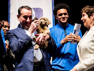 Former head coach Mike Krzyzewski holds Coach on stage at the team's annual awards banquet.