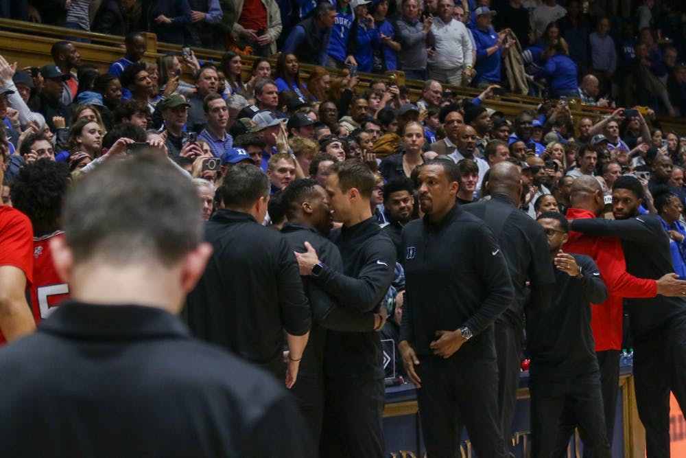Jon Scheyer and Nolan Smith embrace in the moments after Duke's win against Louisville. The two were teammates, co-captains and assistant coaches together at Duke.