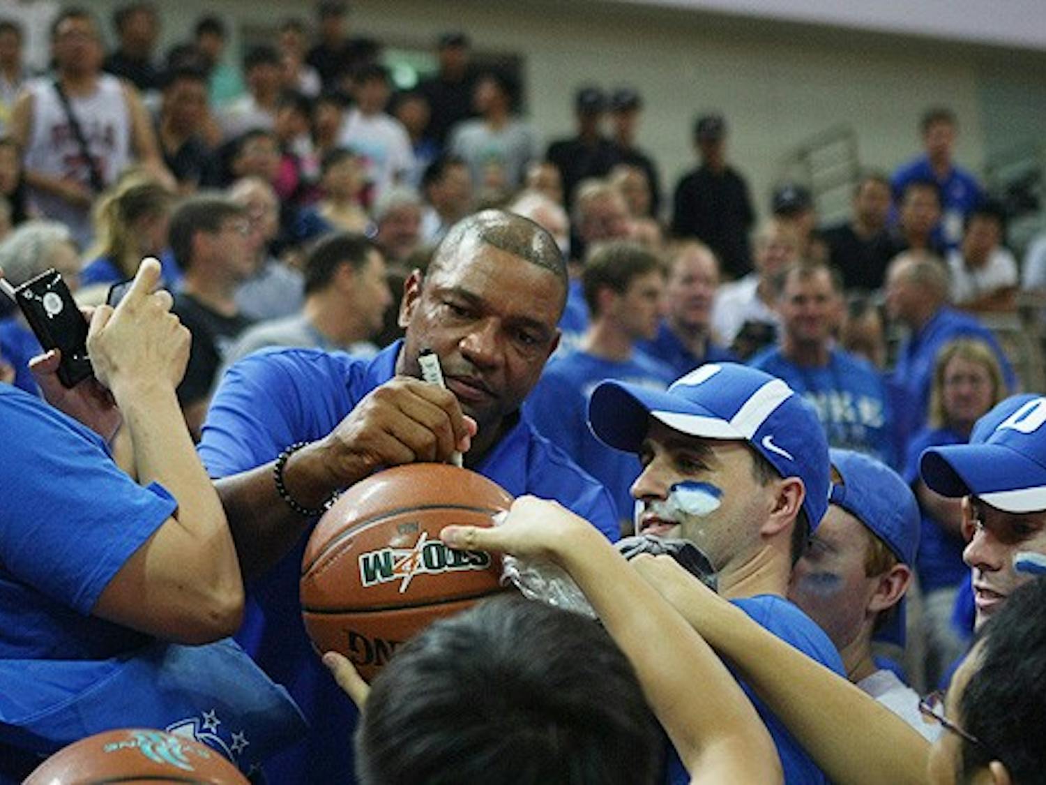 Boston Celtics coach Doc Rivers, father of Duke freshman Austin Rivers, signs autographs at one of Duke’s games in China.