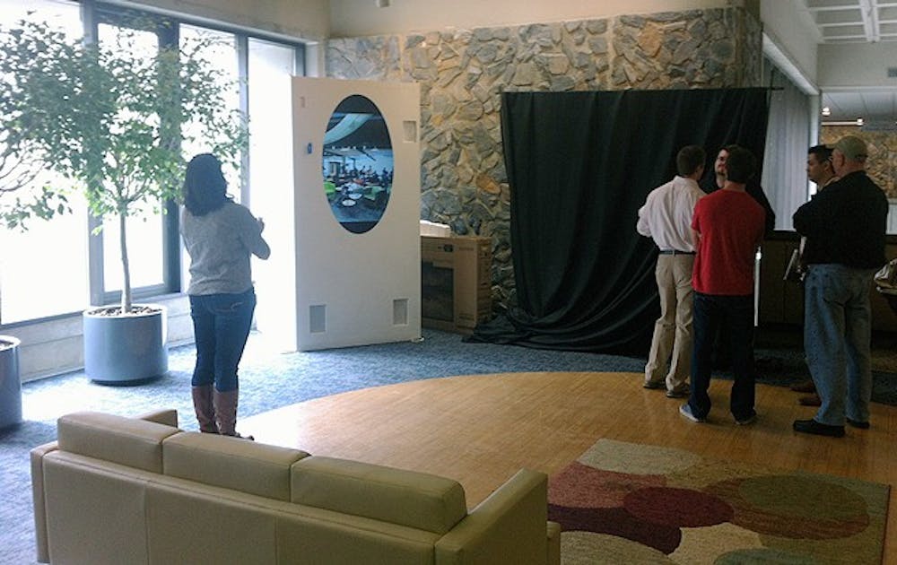 Students and staff look into a new video portal to the University of North Carolina at Chapel Hill. The Bryan Center installation is a collaborative project between the two universities.