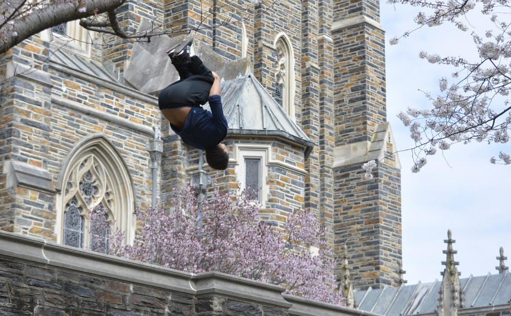 Senior David Ivey flips off a wall near the Duke chapel.