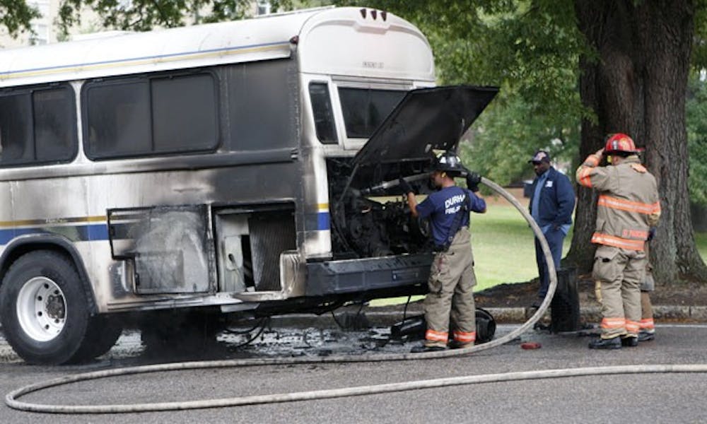 Firefighters from the Durham Fire Department inspect a burnt bus after it caught on fire on East Campus Wednesday afternoon. No one was injured during the incident.