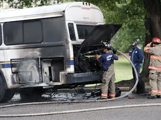 Firefighters from the Durham Fire Department inspect a burnt bus after it caught on fire on East Campus Wednesday afternoon. No one was injured during the incident.