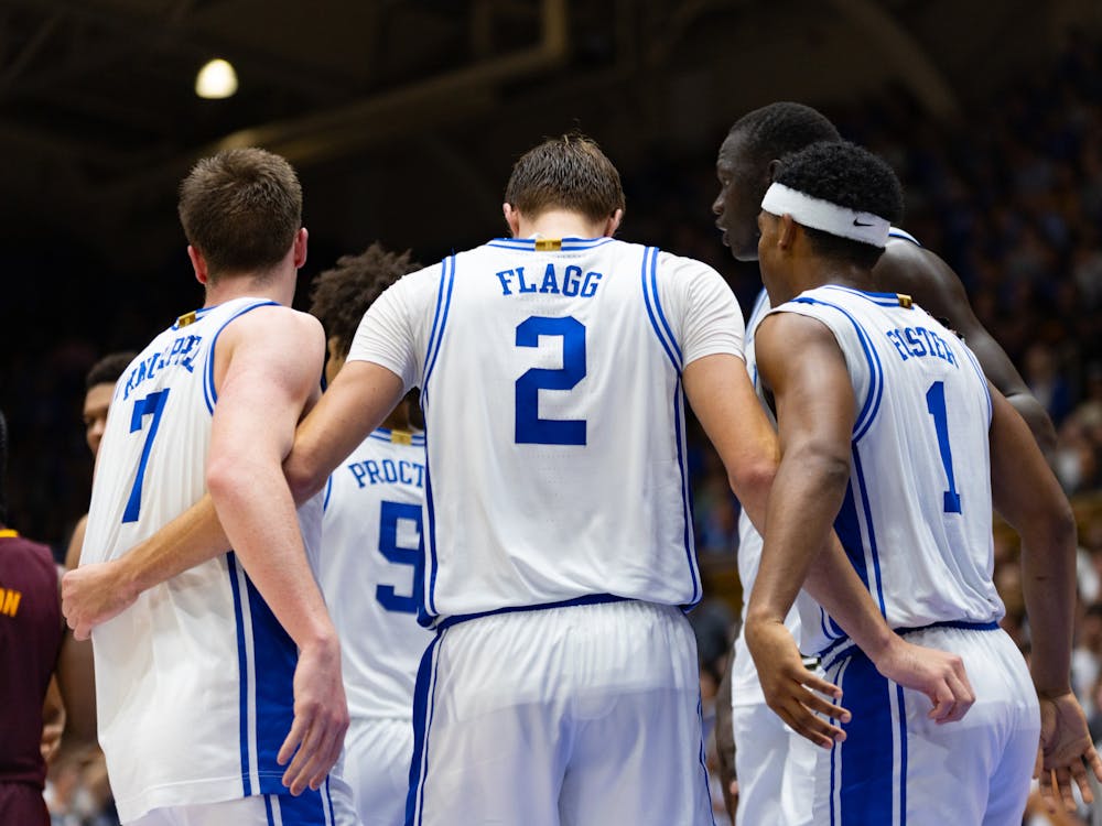 The Duke men's basketball team meets in a huddle.