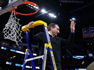 Former head coach Mike Krzyzewski cuts down the net after Duke earned a trip to the Final Four in 2022.