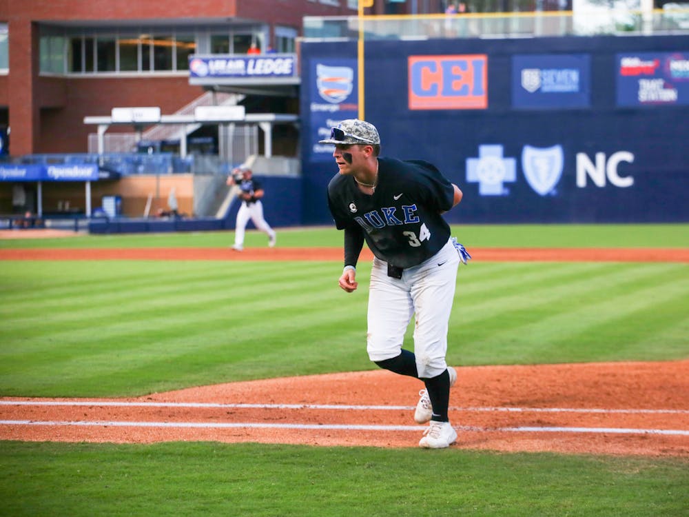 <p>Luke Storm jogs to the dugout in Duke's April 4 win against Campbell at Durham Bulls Athletic Park.</p>