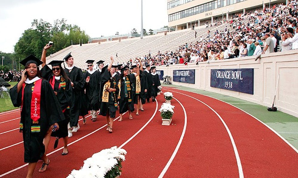 Members of the undergraduate Class of 2010 wave to friends and family as they walk to their seats.