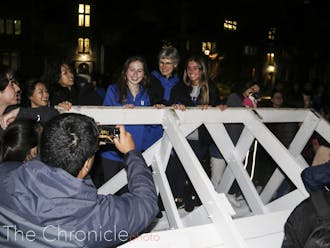 Dean of Students Sue Wasiolek poses for photo with students atop the bench. 