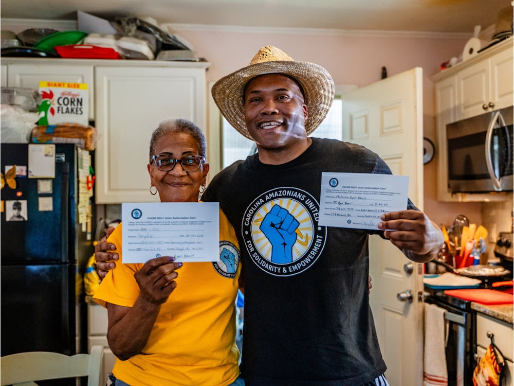 <p>CAUSE leaders Mary "Ma Mary" Hill (left) and Rev. Ryan Brown (right) show their signed union authorization cards.</p>