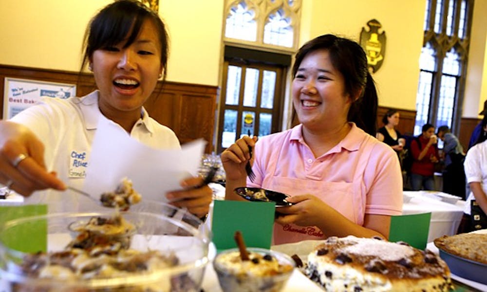 Two restaurateurs from Grand Asia Market, who served as judges, enjoy sweets served at the Dessert Expo in the Great Hall Monday evening. The event, hosted by the Culinary Society, received positive reviews from attendees.