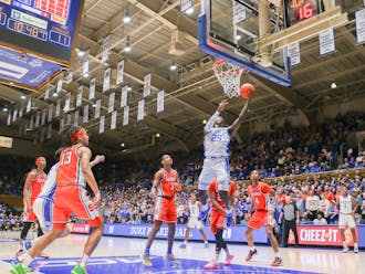Mark Mitchell lofts the ball in under the basket during Duke's first half against Syracuse.
