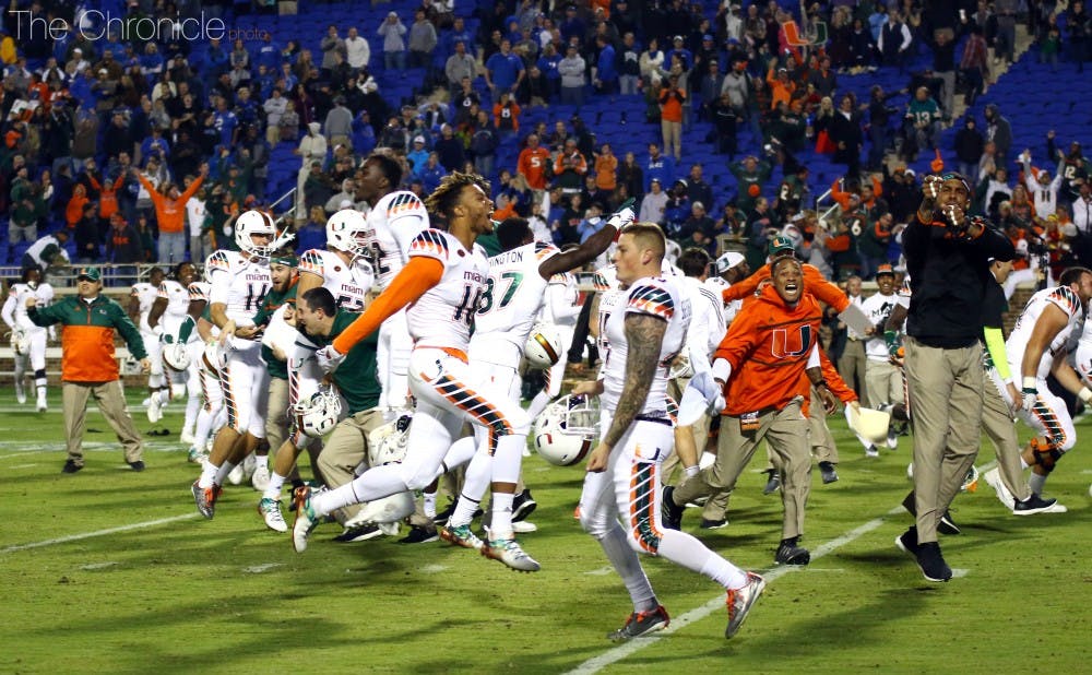 Miami players and coaches react after Corn Elder capped a wild kickoff return with a touchdown to give the Hurricanes a 30-27 win Saturday night.