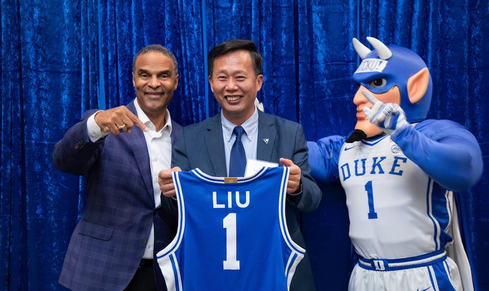 Duke Provost Alec Gallimore and the Duke Blue Devil present DKU Chancellor Yaolin Liu with his own Duke basketball jersey.