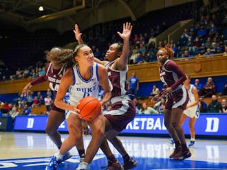 Duke guard Celeste Taylor absorbs contact in the paint in the Blue Devils' 71-52 win at Cameron Indoor Stadium.