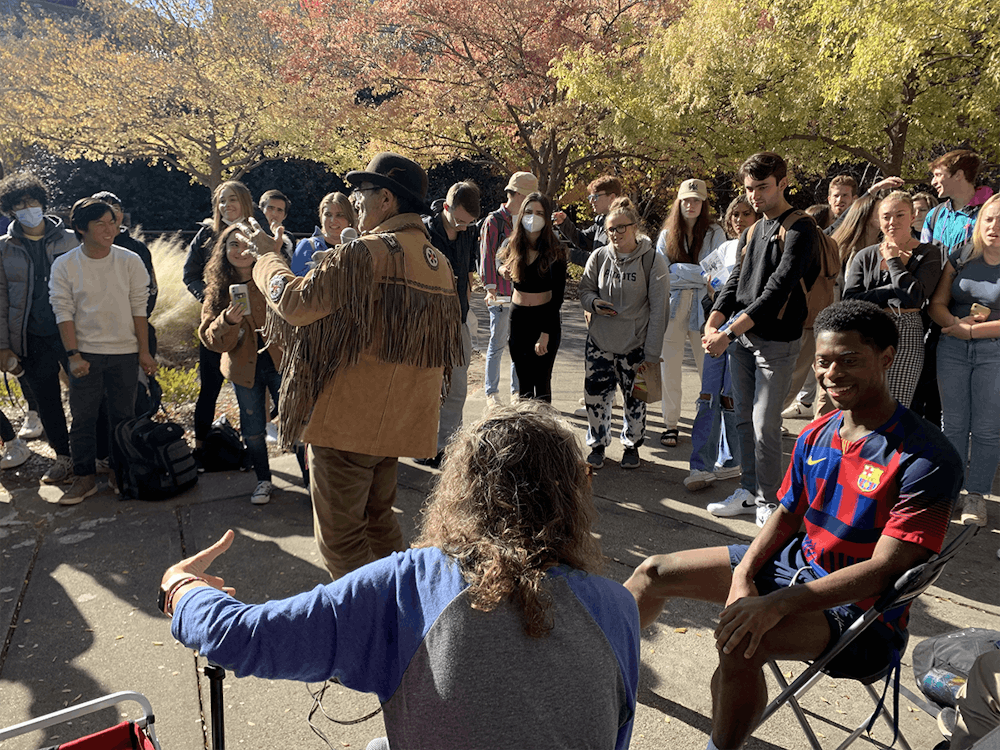 Jed Smock, background center, addresses students near the Bryan Center Tuesday. Cindy Smock, foreground center, speaks to an individual student in a lawn chair.