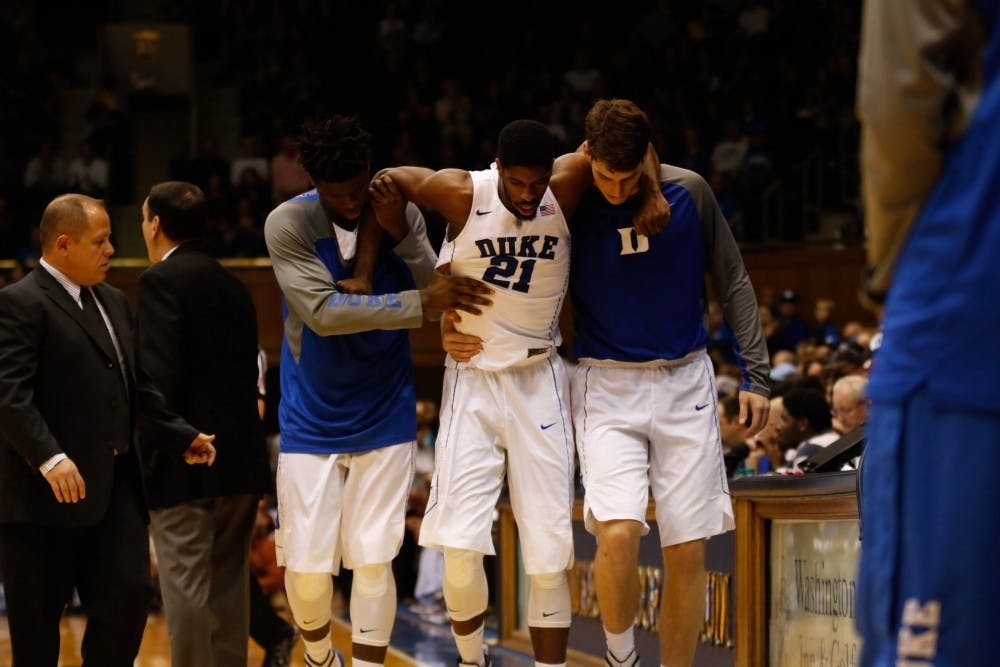 <p>Amile&nbsp;Jefferson is helped off the floor in November after an ankle injury. His indefinite absence from the Blue Devil lineup due to a right foot injury will test an already-thin Duke frontcourt.</p>