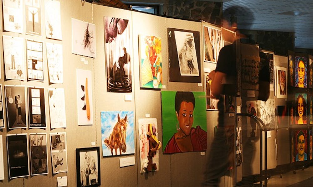 A student gazes at the student art on display in the Bryan Center during the inaugural Duke Arts Weekend, which featured art work from alumni, as well as undergraduate and professional students.