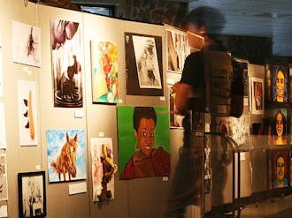 A student gazes at the student art on display in the Bryan Center during the inaugural Duke Arts Weekend, which featured art work from alumni, as well as undergraduate and professional students.