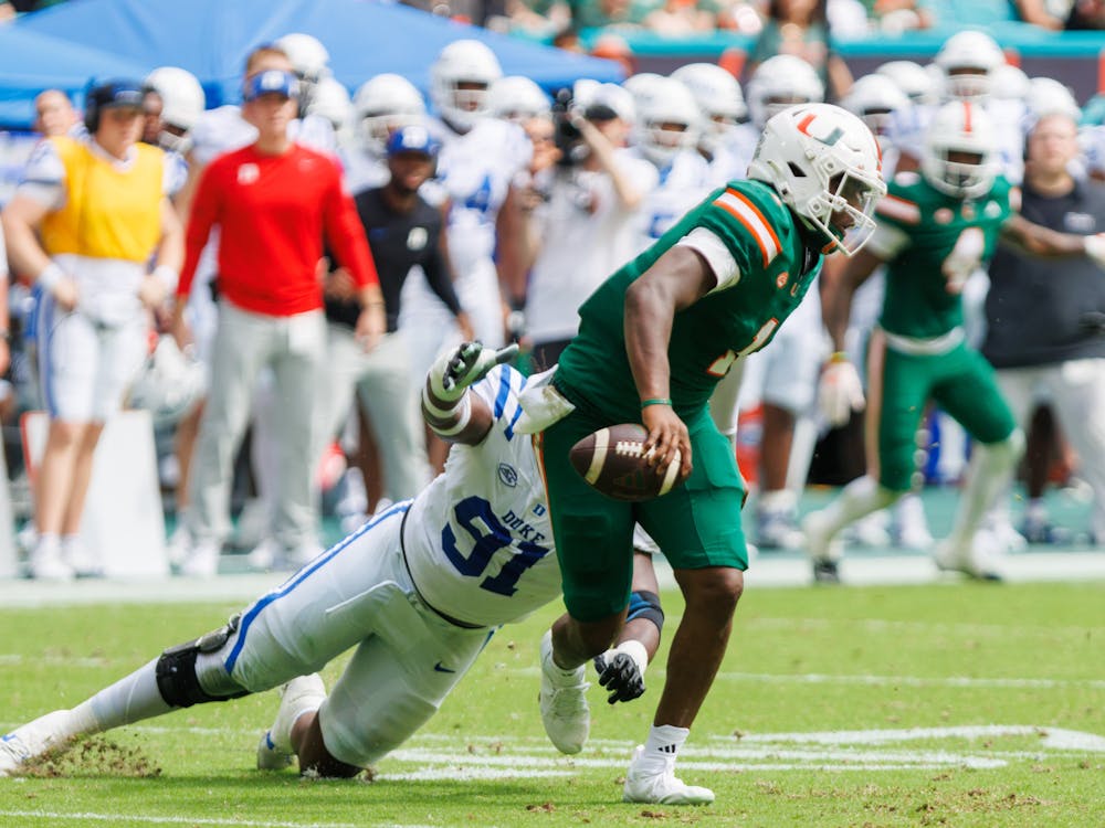 Kendy Charles chases after Miami quarterback Cam Ward. 