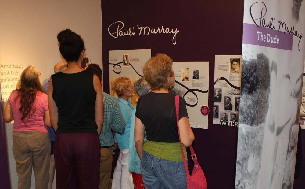<p>Visitors to the Pauli Murray exhibit analyze the works on display at the Scrap Exchange. </p>
