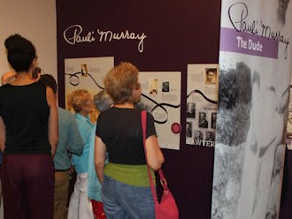 Visitors to the Pauli Murray exhibit analyze the works on display at the Scrap Exchange. 