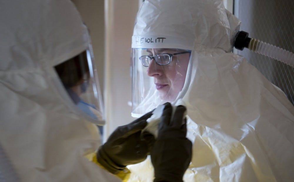 Angela Hewlett, assistant medical director of the Nebraska Biocontainment Patient Care Unit at the Nebraska Medical Center in Omaha, Neb., gets assistance putting on protective gear during a drill in February at the biocontainment unit, where an Ebola patient is being treated. Illustrates EBOLA-DOCTOR (category a), by Angela Hewlett, Special to The Washington Post. Moved Sunday, Oct. 12, 2014. (MUST CREDIT: Taylor Wilson/Nebraska Medical Center)