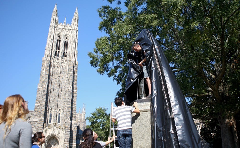Members of DukeOpen wrap the James B. Duke statue on West Campus to promote endowment transparency.