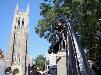 Members of DukeOpen wrap the James B. Duke statue on West Campus to promote endowment transparency.
