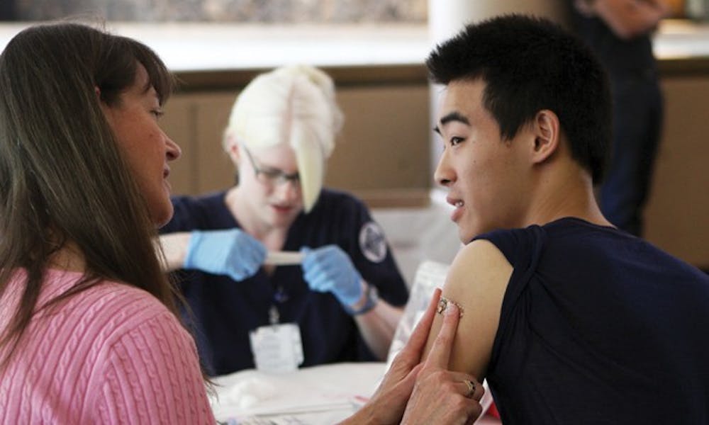 A student receives a flu shot in the Bryan Center.