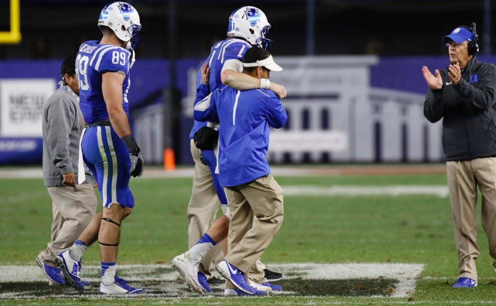 Quarterback Thomas Sirk is helped off the field after sustaining an injury in overtime. After the game, head coach David Cutcliffe said Sirk's availability for double overtime would have been in doubt.