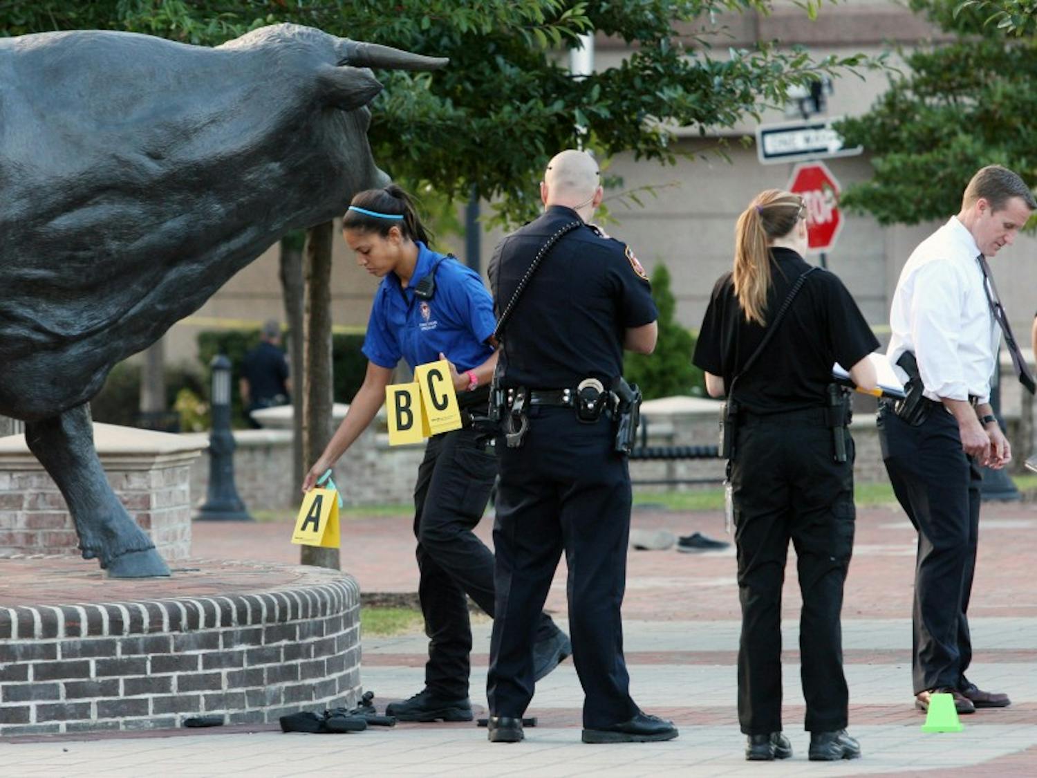 A crime scene investigator marks evidence at the site of the shooting.