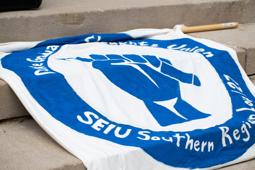 <p>The Duke Graduate Students Union drapes a banner on the Chapel steps during a rally on Sept. 5, 2022. &nbsp;</p>