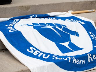 The Duke Graduate Students Union drapes a banner on the Chapel steps during a rally on Sept. 5, 2022. &nbsp;