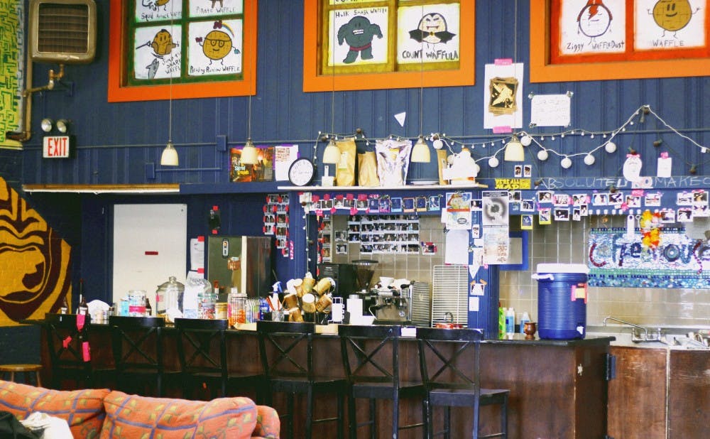Polaroids line the wall behind the counter at Duke Coffeehouse on East Campus, which turns 50 this year.