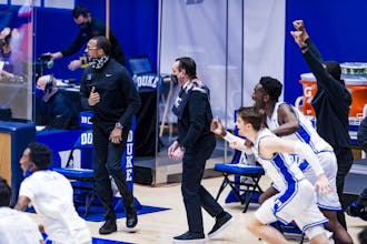 Duke's sideline celebrates after Virginia's last-second shot attempt falls short at the buzzer.