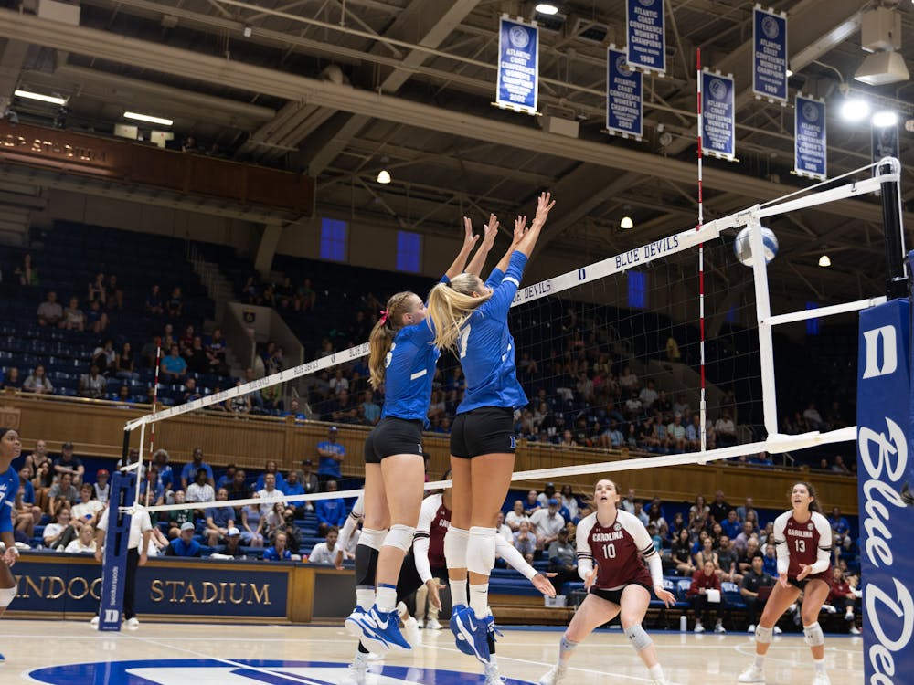 Senior Ryle Kadel and graduate Grace Penn rise above the net for Duke against South Carolina.