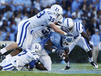 Despite being surrounded by several Duke defenders, Tar Heel running back Ryan Houston (32, center) gains ground in his team’s win Saturday.