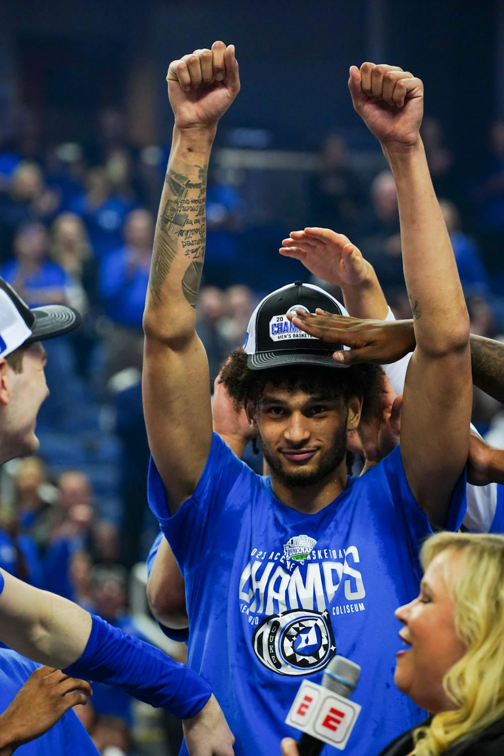 Freshman center Dereck Lively II celebrates on the stage following Duke's ACC title victory at Greensboro Coliseum.
