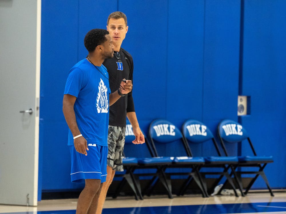 Associate head coach Jai Lucas (left) and head coach Jon Scheyer (right) give instructions during a summer practice.