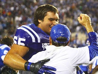 Cutcliffe, pictured here with Cody Robinson, a senior on the 2012 roster, had a 14-season tenure which included a stretch of six bowl games in seven years, including the 2012 Belk Bowl, the program's first since 1995. 