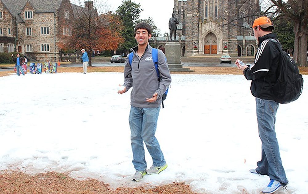 Students take a break to play in the snow before buckling down for finals. Several inches of man-made snow covered the Chapel Quadrangle Friday morning, in an event sponsored by Duke University Union.