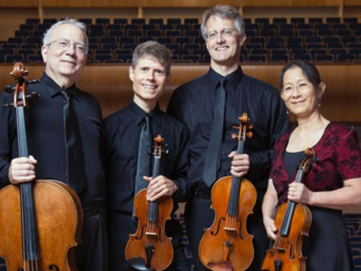 The Ciompi Quartet­—comprised of Eric Pritchard, Hsiao-mei Ku, Jonathan Bagg and Fred Raimi—smiles with their instruments, two violins, a viola and cello.
