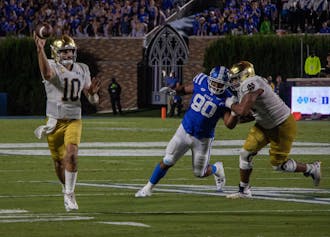 Sam Hartman (left) escapes the pocket during Duke's loss to Notre Dame.
