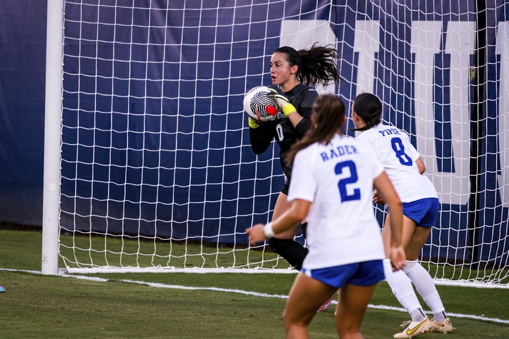 Kat Rader (2) and Elle Piper (8) look on as goalkeeper Leah Freeman (0) saves a shot during Duke's win against West Virginia.